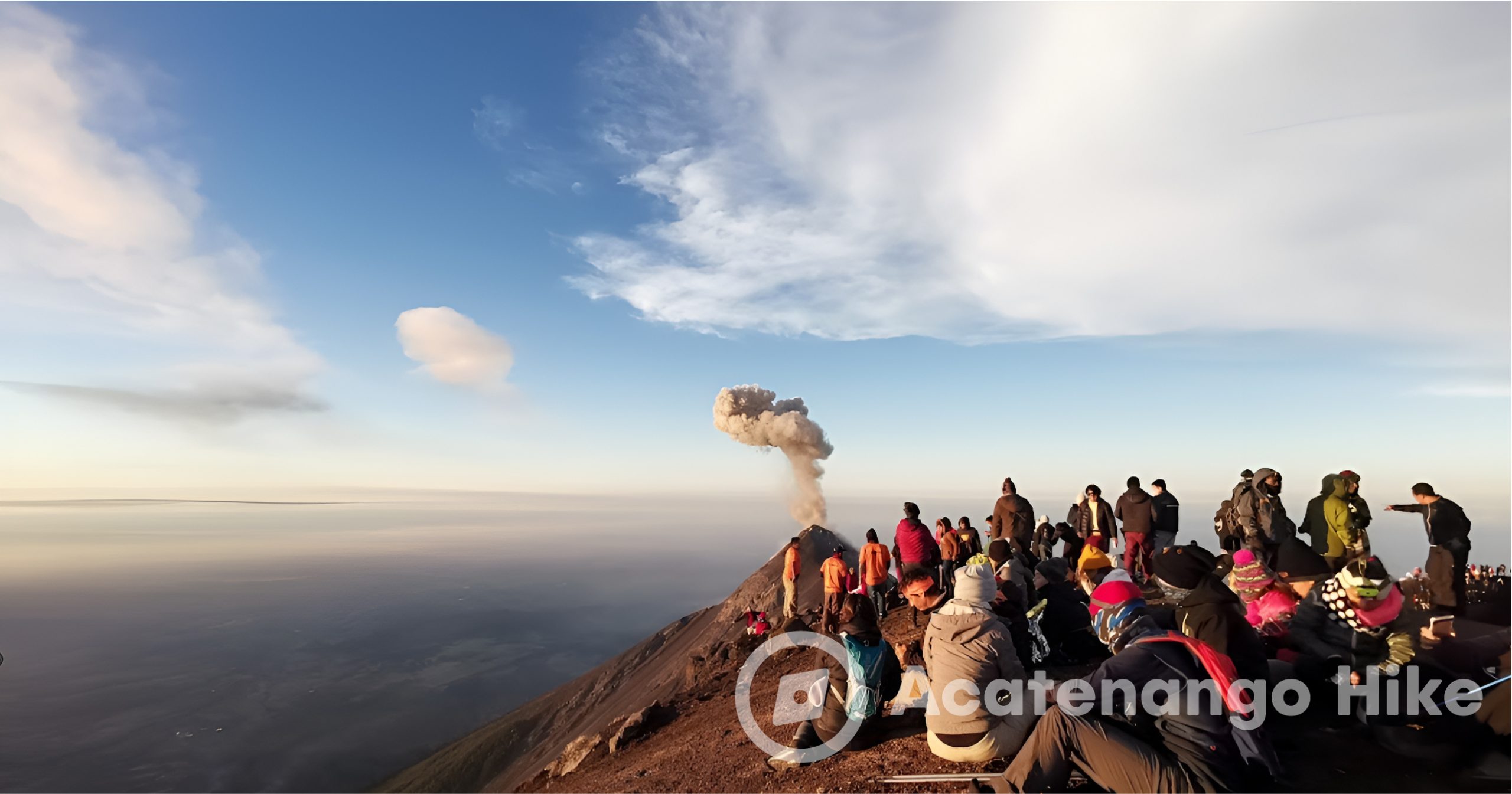 Foto em grupo no cume do Acatenango com nuvens e fumaça do Vulcão de Fuego