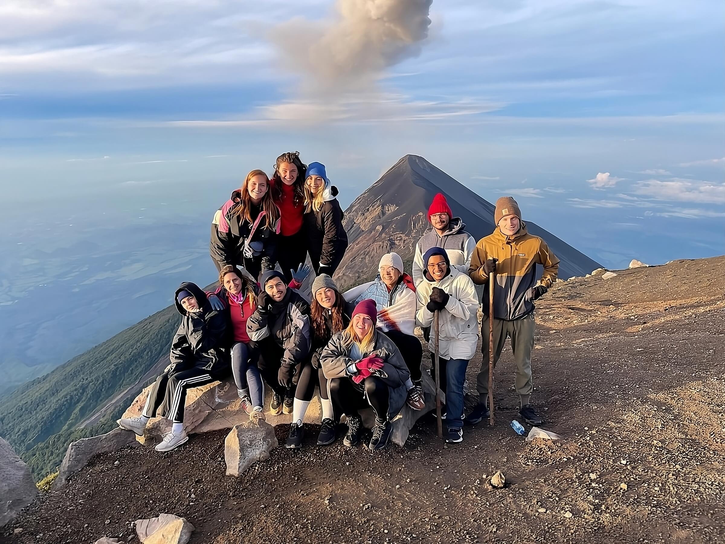 Foto de grupo con el humo del Volcán de Fuego desde la cumbre del Acatenango