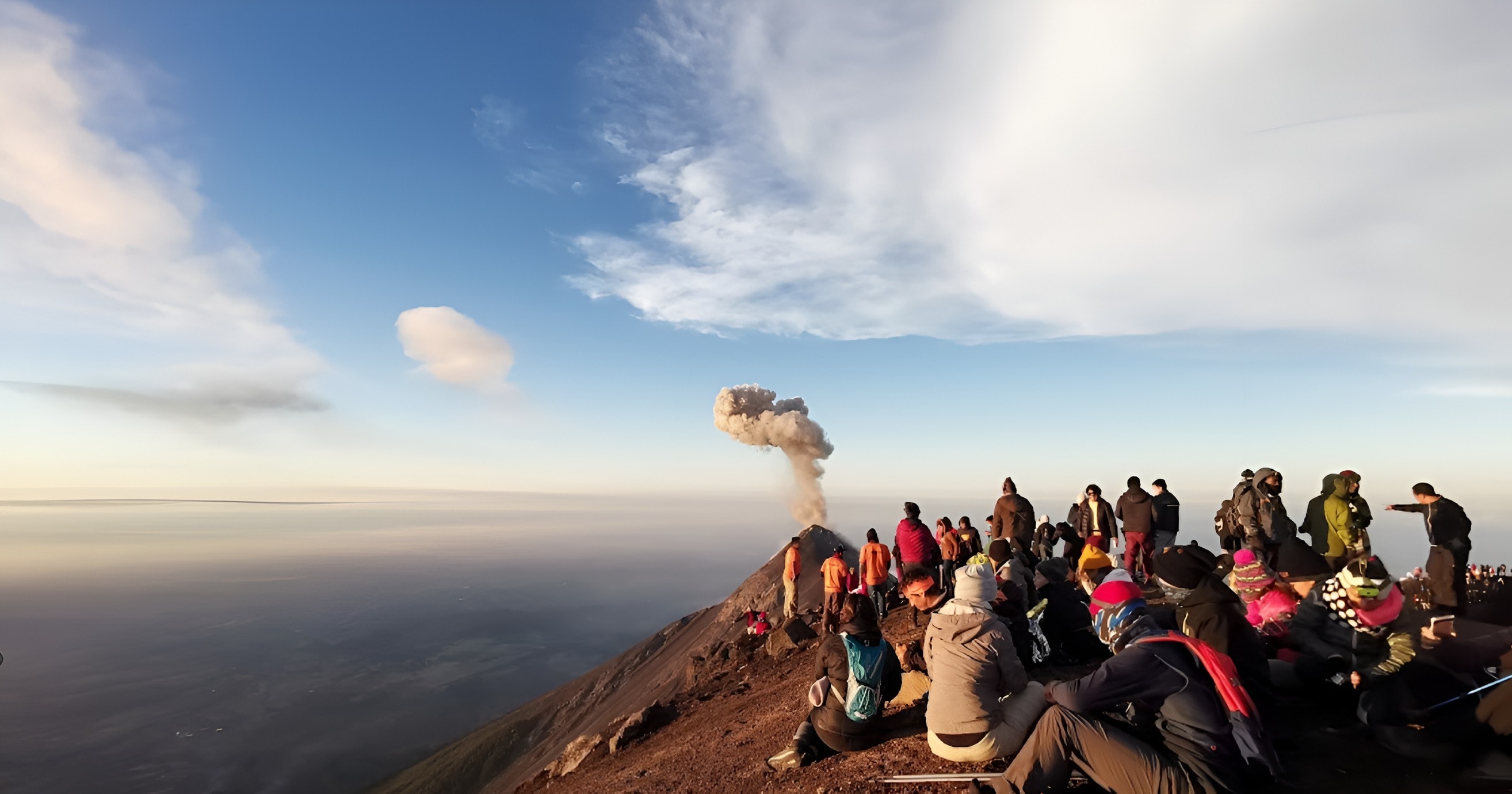 Turistas observando a erupção do Vulcão de Fuego ao nascer do sol no Acatenango