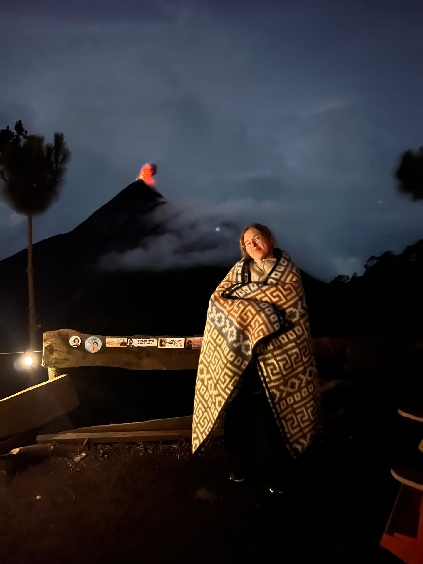 Traveler wrapped in a blanket at base camp as Volcán de Fuego erupts